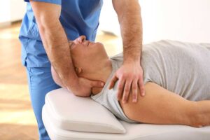 Senior man and woman receiving gentle chiropractic adjustments in a bright, professional clinic setting.
